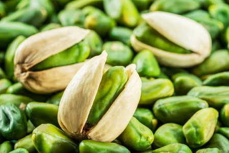 绿色开心果坚果与壳在许多开心果.食品背景照片