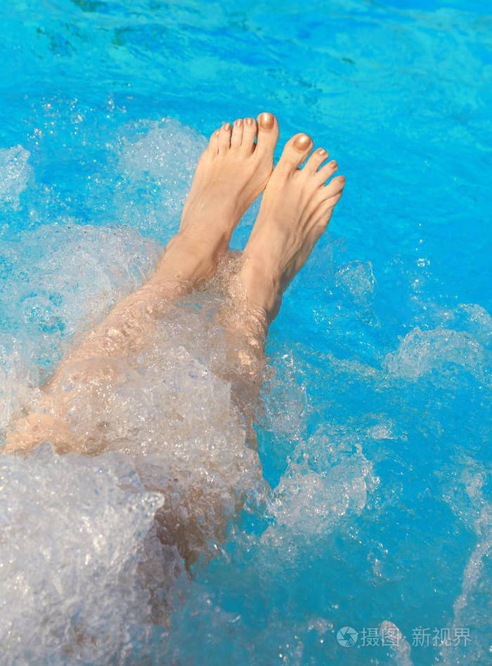 在游泳池的热浴缸里放松的女士的腿