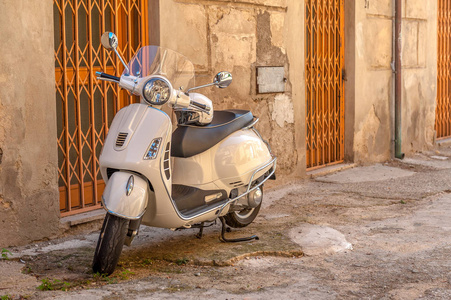 在意大利锡耶纳的一条丑陋的旧街道上, 白色的老式大黄蜂复古摩托车停在那里。复古风格