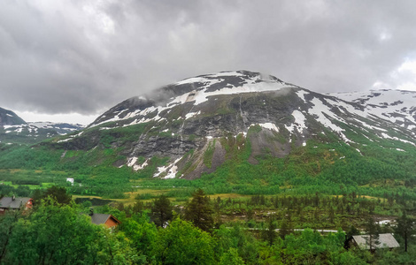 挪威，绿色的小山和山的风景美丽的山水风光景色部分覆盖着雪