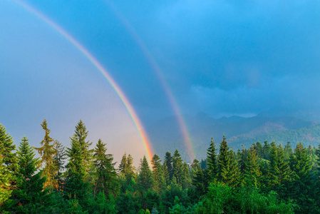 雨后特写山背景下两个彩虹的美丽自然现象