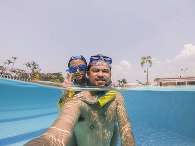 快乐的年轻亚洲孩子和爸爸在水下游泳镜, 显示和平