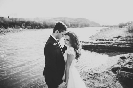 幸福新婚夫妇摆造型和微笑的婚纱礼服和西装户外, 黑白