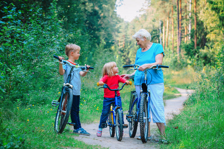 孩子们骑着自行车在自然快乐祖母