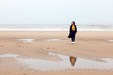 女孩雨海风冬天画像妇女微笑春天外套长的头发卷曲的心情海岸雪海滩