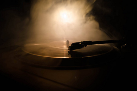 黑胶唱片正在对阵燃烧火与烟的背景.年份照片