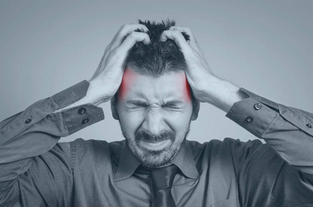 劳累过度的企业商人头痛得厉害照片