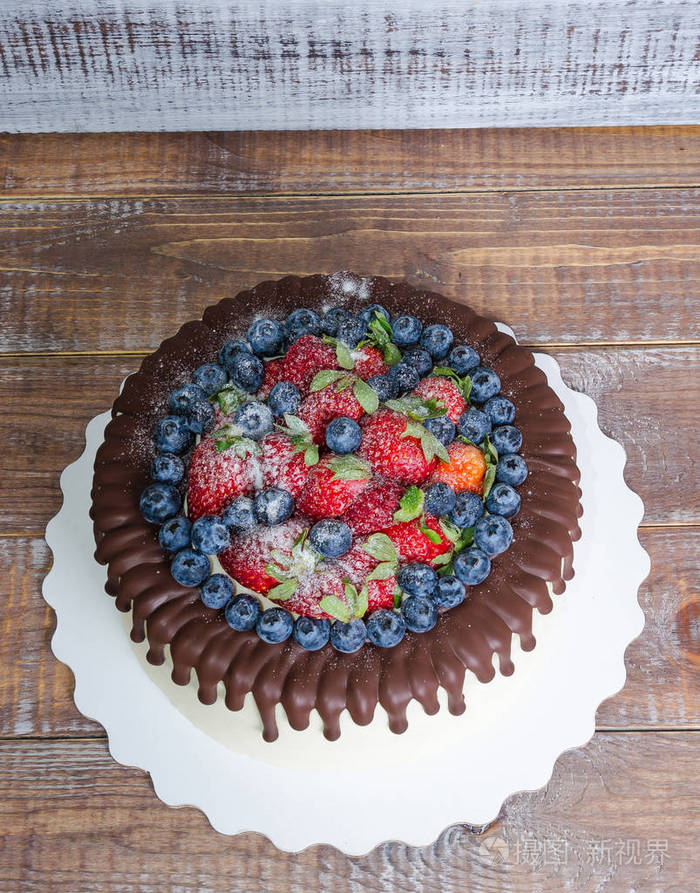巧克力色滴蓝莓和草莓蛋糕和