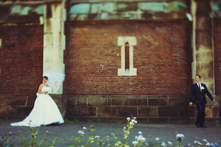 新娘和新郎站分开背后旧砖世界图片