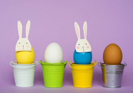 在彩色水桶，选择性聚焦图像卡快乐复活节兔子面具的复活节彩蛋