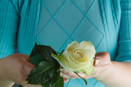 女人的手里拿着一朵白玫瑰图片