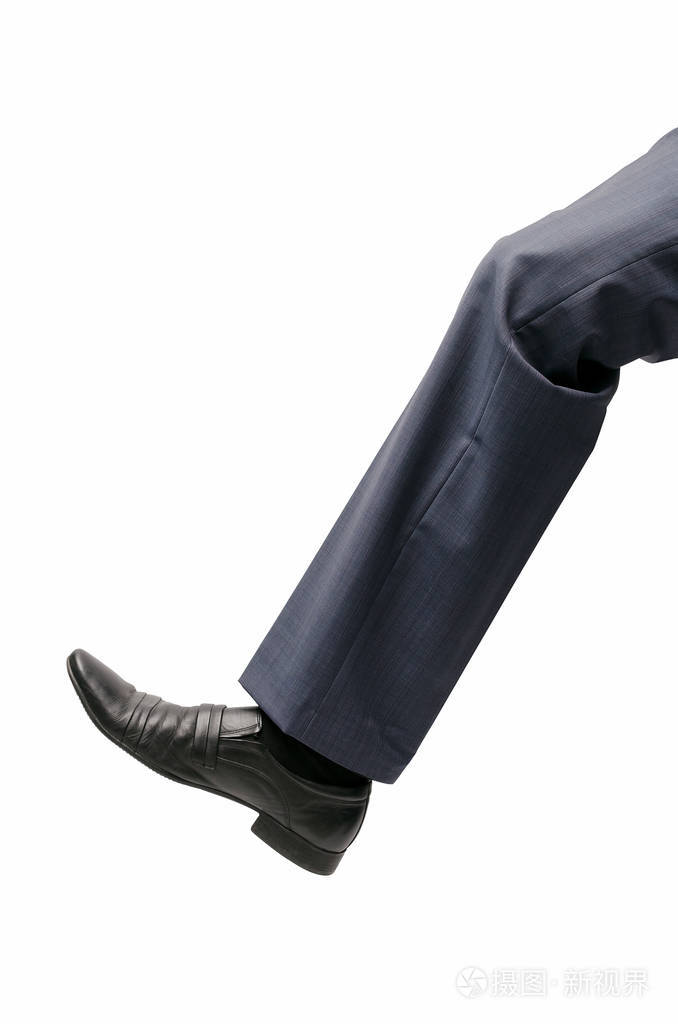 一只巨大的人类脚在白色背景下被隔绝了.一个大商人的腿在裤子和鞋子