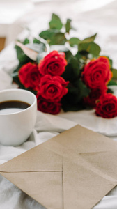 杯咖啡和一束红色玫瑰，信封