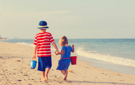 小男孩和女孩在海滩上行走