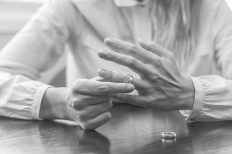 离婚的伟大概念, 结束的关系, 年轻女子从手指拉结婚戒指