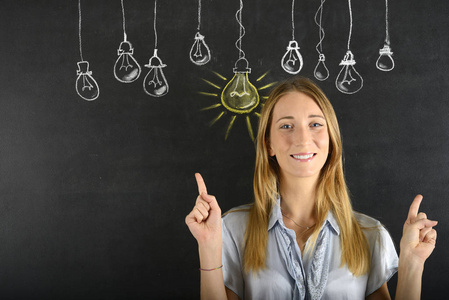 自信的年轻女人和灯泡的大思路照片