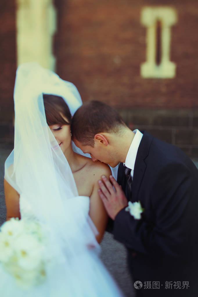 风吹着面纱新娘的脸上虽然新郎亲吻她的肛门照片-正版商用图片0pdv22