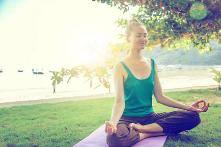 做瑜伽在户外的年轻女人。健康的生活方式冥想