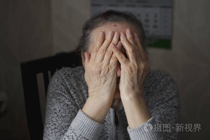 一个坐在桌子上的老妇人处于抑郁状态