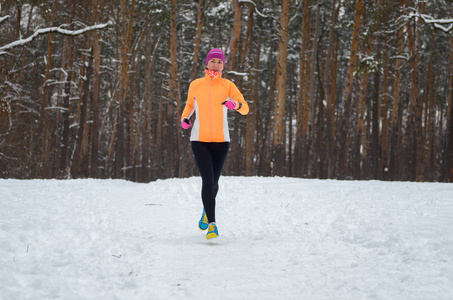 冬天在森林中运行 幸福的女人跑慢跑在雪 户外运动和健身概念