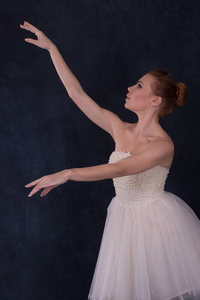 穿着古典白色礼服的芭蕾舞演员在演播室的黑暗背景跳舞, 腰部