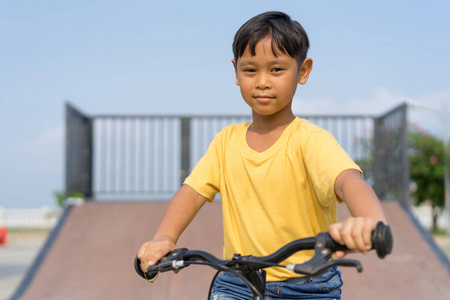 亚洲男孩骑自行车在公共公园