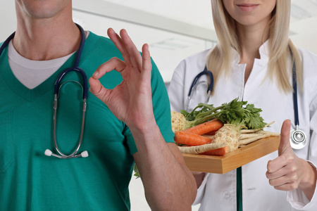 健康饮食的概念。医生拿着铁板与新鲜的蔬菜和显示竖起大拇指