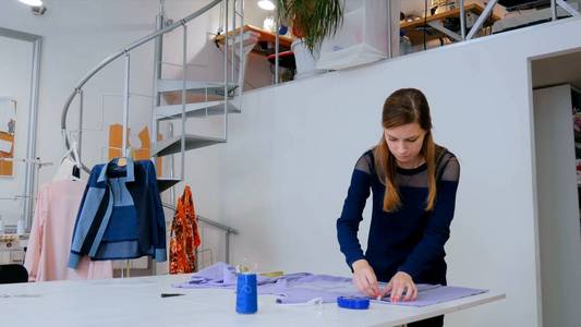 裁缝，设计师在缝纫工作室在织物上画线