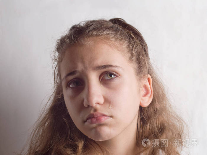 灰色背景下的悲伤女孩肖像