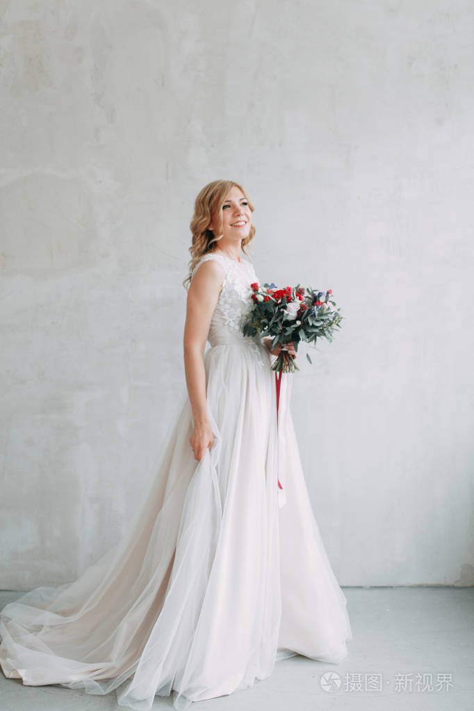 美丽的新娘在一个明亮的时尚工作室的婚纱礼服.欧洲风格的婚礼.