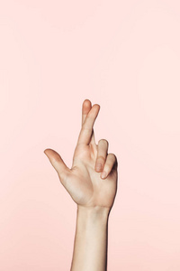 裁剪图像的女人做交叉手指手势孤立粉红色背景
