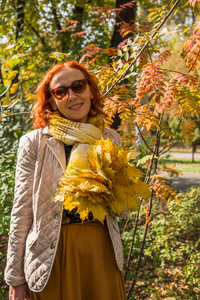 秋天公园的老妇人与色的叶子