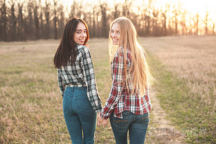 照片 晚上在田野上散步的两个开朗的年轻女子.最好的朋友.jpg