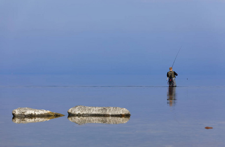 钓鱼在蓝色平静的海中, 试图捕捉鳟鱼在 Aleklinta 岛 Oland, 瑞典