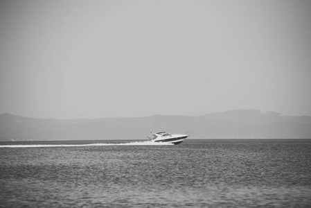 快艇。高速船在海, 蓝天和山在背景。在海面上滑行的白色豪华游艇的惊人景色