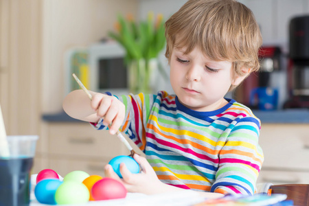 复活节假期着色鸡蛋的小小孩男孩