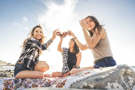 一群年轻女性朋友一起在特内里费岛的岩石海滩上喝果汁。一个团队享受假期和快乐的关系