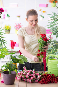 年轻妇女在她的花园浇水植物