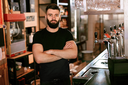 啤酒酒吧酒保站在酒吧柜台的年轻人的肖像.高分辨率照片