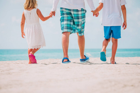 父亲与儿子和女儿在海滩散步