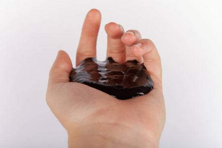 手持黑色粘液的儿童手照片