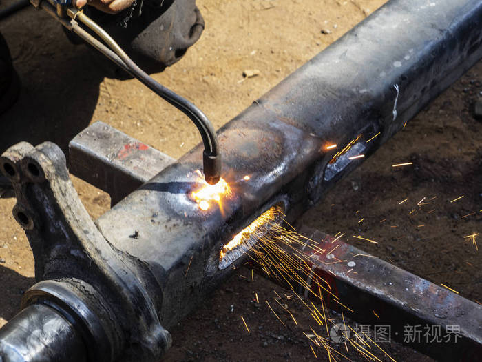 金属工作。用气体焊接在钢件上切割一个洞