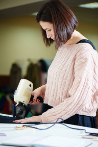 黑头发女裁缝工作室用专业工具裁剪纺织品