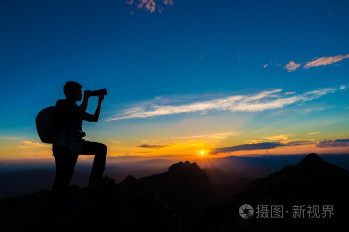 山上的摄影师男人达到太阳