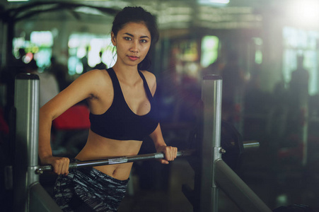 体育亚洲妇女在健身馆锻炼杠铃