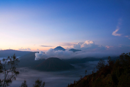 白烟来自火山包围的雾和清澈的蓝天白云