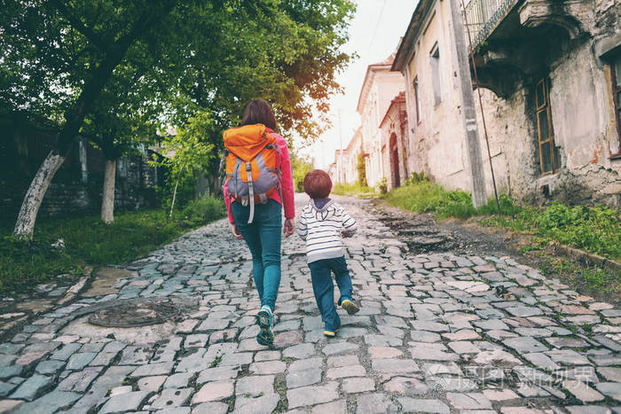 一个男孩和他的母亲正在老城里散步.