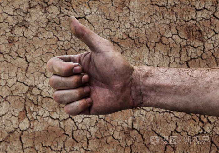 脏手的人竖起大拇指上孤立的土壤