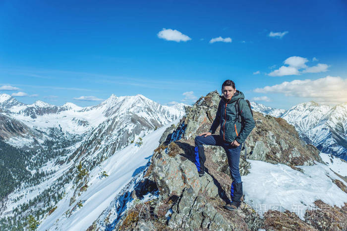 徒步旅行者站在山顶上在晴朗的天气里仰望天空和雪山旅游理念与实现