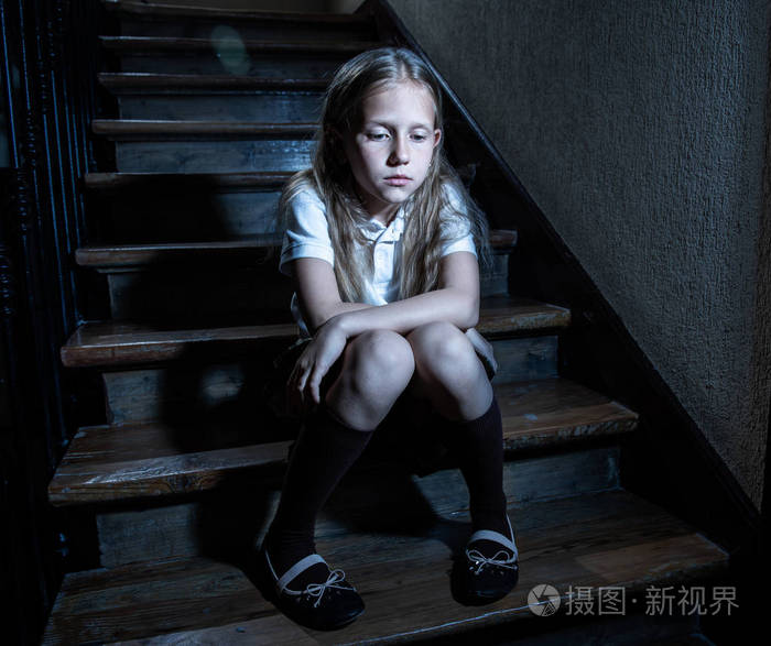 悲伤, 沮丧, 不快乐的女孩遭受欺凌和虐待感到孤独和无望坐在楼梯上, 暗光。学校隔离欺凌骚扰和虐待概念